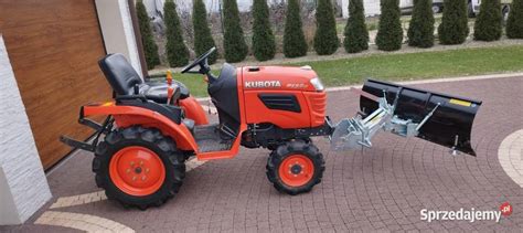 Traktorek wielofunkcyjny z zamontowanym pługiem do odśnieżania