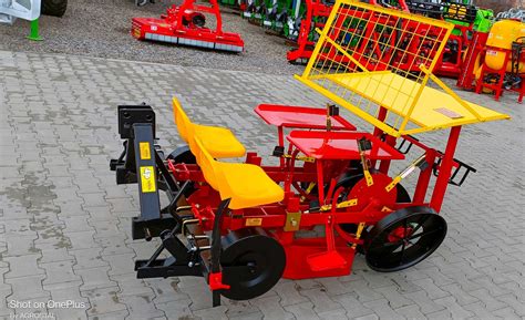 Zdjęcie przedstawiające różnorodne części zamienne do sadzarki ziemniaczanej, takie jak koła łańcuchowe, lemiesze, sprężyny i znaczniki.