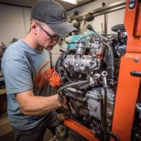 Photo of a Kubota service technician working on a mower engine
