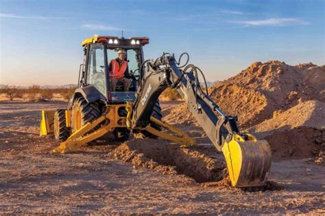 Thematic photo of an older John Deere backhoe loader from the 1980s or 1990s, working on a budowie
