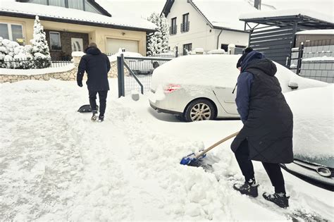 Zdjęcie osoby odśnieżającej mały podjazd odśnieżarką elektryczną