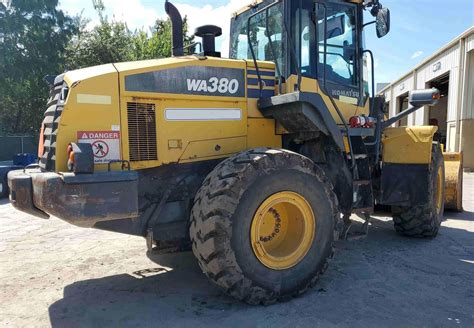 Wnętrze kabiny ładowarki Komatsu WA380-7, ukazujące ergonomię stanowiska operatora i monitor