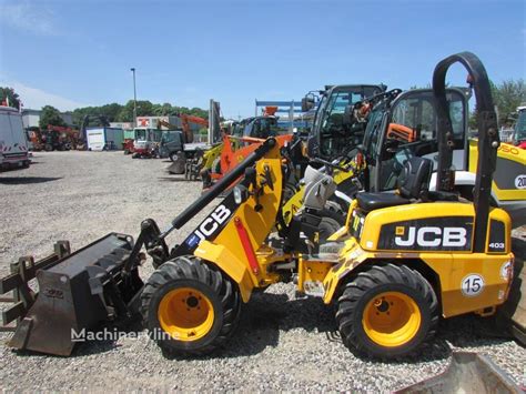 The JCB 403 compact wheel loader in action, loading material.