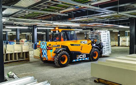 Electric JCB TH 525-60E telescopic loader working in a warehouse, emphasizing its compact size and zero emissions. (Thematic photo)
