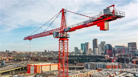 Photo of a modern tower crane performing a complex lifting operation on a large construction project, emphasizing its precision and efficiency.