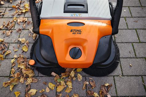 Zamiatarka STIHL KG 770 w akcji zamiatająca różnorodne odpady, w tym puszki