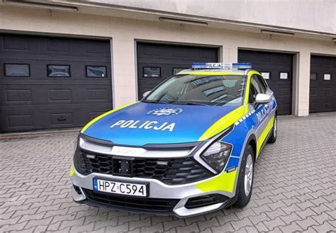Zdjęcie przedstawiające policyjny radiowóz i odzyskany ciągnik rolniczy