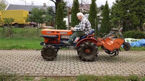 Mały traktorek z glebogryzarką pracujący w szklarni.