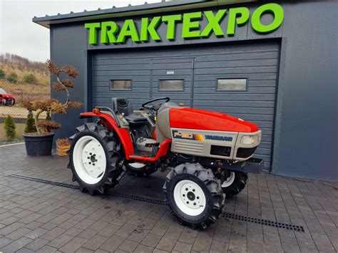 Mały traktorek miejski zamiatający chodnik zimą.