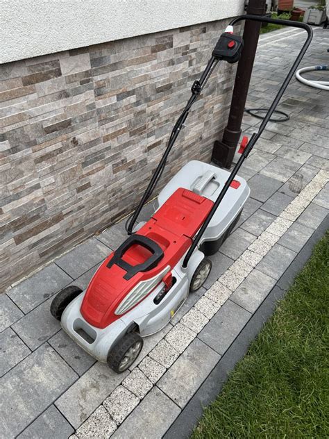 Zdjęcie przedstawiające nowoczesną kosiarkę elektryczną marki WOLF-Garten w przydomowym ogrodzie.