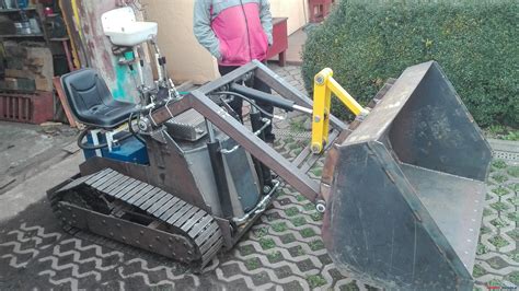 Koparko-ładowarka gąsienicowa pracująca na trudnym, błotnistym terenie
