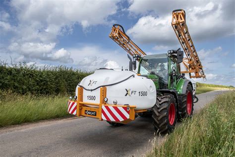 Thematic photo of a used mounted sprayer in a field, possibly being inspected by a potential buyer.