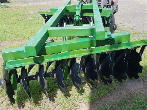 Photo of a severely worn disc harrow plate next to a new one for comparison