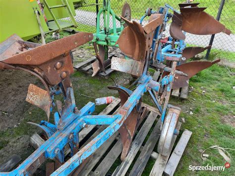 Zbliżenie na mechanizm obrotowy pługa z widoczną osią o dużej średnicy.