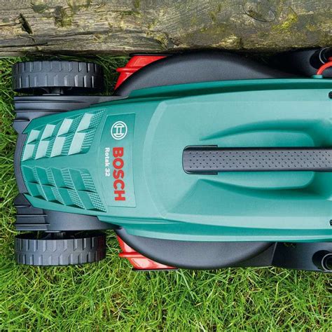 Ilustracja przedstawiająca kosiarkę Bosch Rotak 32 w akcji na zielonym trawniku