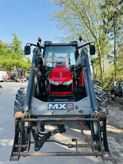 zdjęcie traktora Massey Ferguson z ładowaczem czołowym w akcji, pokazujące wyzwania terenowe