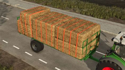 Przyczepa na bele z załadowanymi paletami wełny w Farming Simulator