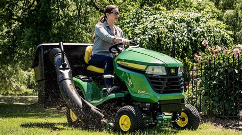 The John Deere AX 75 lawn tractor in action, cutting grass in a garden. The image should highlight its compact size and maneuverability.