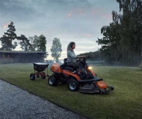 Thematic photo of a person operating a ride-on lawnmower in a large garden