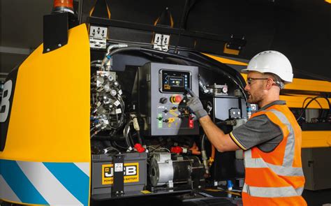 Zdjęcie mechanika Interhandler używającego urządzenia diagnostycznego przy maszynie JCB