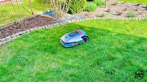 Robot koszący w akcji na nierównym terenie ze wzniesieniem