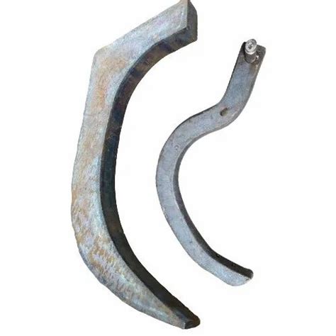Close-up of the cultivator's tines with spring protection and side wings, showing the soil-working action.