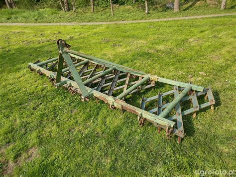 Zdjęcie polowe brony wahadłowej podczas pracy z wyraźnie zaznaczonymi deflektorami bocznymi