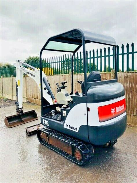 The Bobcat E16 compact excavator operating in a confined space, showcasing its maneuverability and compact design.