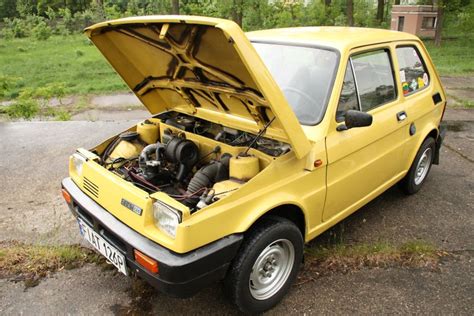 Zdjęcie porównawcze małego samochodu (np. Fiat 126p) z prototypem traktorka-kosiarki DIY