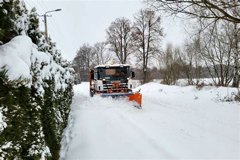 Zdjęcie przedstawiające elektryczną ciężarówkę Scania wyposażoną w pług śnieżny podczas pracy w trudnych warunkach zimowych