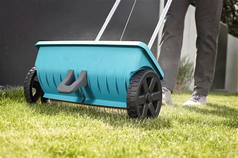 Uniwersalny siewnik Gardena w użyciu, rozsiewający nasiona na trawniku