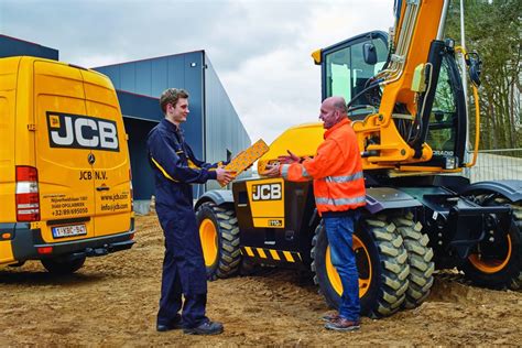 Technician servicing a JCB loader on-site with a mobile service vehicle