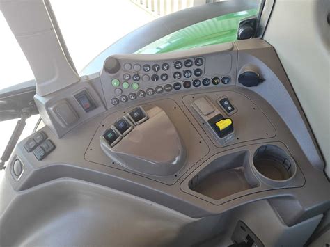 Zdjęcie wnętrza kabiny John Deere 6120M lub innej serii 6M z widocznym panelem sterowania