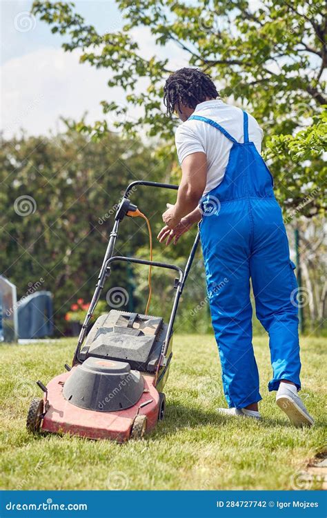 Thematic photo of a person effortlessly starting a gasoline lawnmower with a button