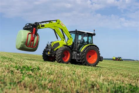 Claas Axos 200 z ładowaczem czołowym podczas pracy na polu