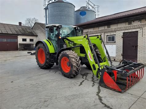 Ciągnik Claas Elios 300 z ładowaczem czołowym w gospodarstwie