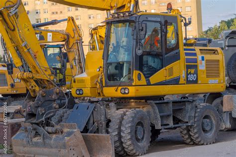 Koparka kołowa Komatsu PW140 na placu budowy w trakcie pracy