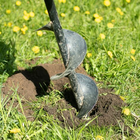 Thematic photo of a person operating an earth auger in a garden