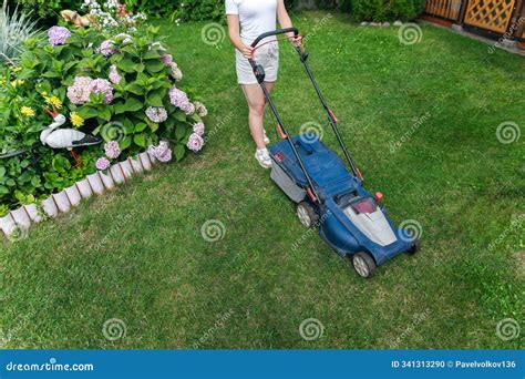 Thematic photo of a person mowing a well-maintained lawn with a modern lawnmower