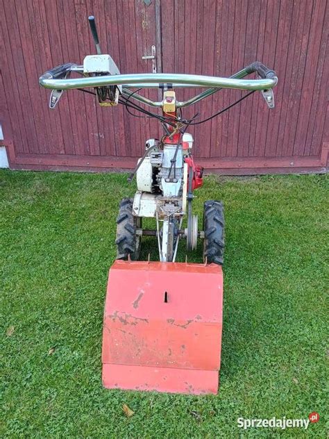 Zbliżenie na pracującą glebogryzarkę zamontowaną do ciągnika jednoosiowego