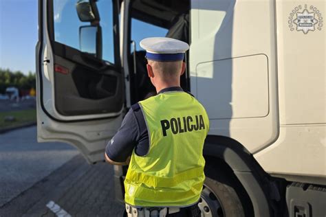 Zdjęcie policjanta kontrolującego dokumenty kierowcy ciągnika