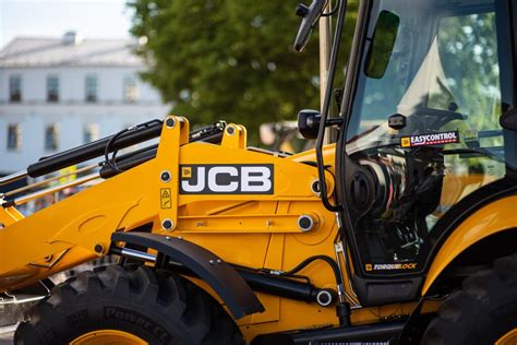 Tematyczne zdjęcie koparko-ładowarki JCB w pracy na placu budowy