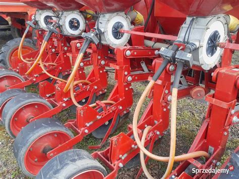 Ilustracja nowoczesnego siewnika do zboża i kukurydzy z widocznym elementem dozowania nawozu.