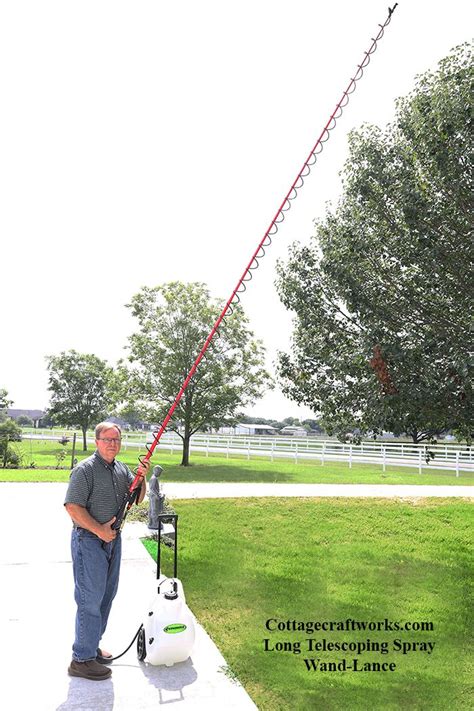 Thematic photo of a person using a garden sprayer with a long lance in a garden.