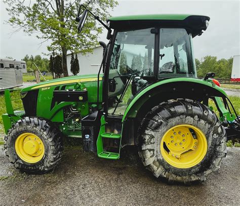 Thematic photo of a tractor with a rear loader operating on a farm, showing its versatility in handling various materials.