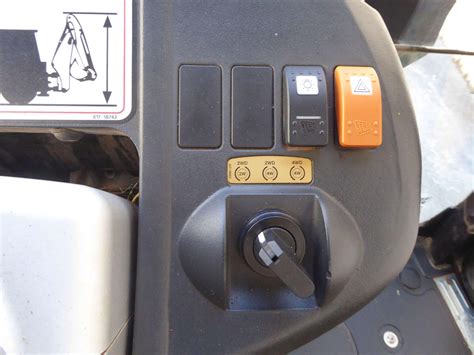 Panel kontrolny ładowarki JCB z widocznymi kontrolkami ostrzegawczymi