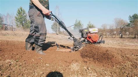 Thematic photo of a person operating a tiller, with a focus on their hand on the throttle lever.