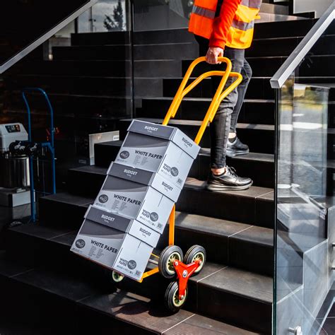 Ilustracja przedstawiająca osobę obsługującą wózek schodowy transportujący ładunek po schodach