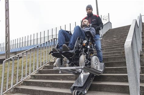 Zdjęcie schodołazu osobowego pomagającego osobie na wózku inwalidzkim pokonywać schody