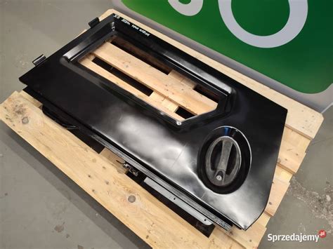 Zdjęcie szyby dolnej drzwi JCB z widocznymi wymiarami